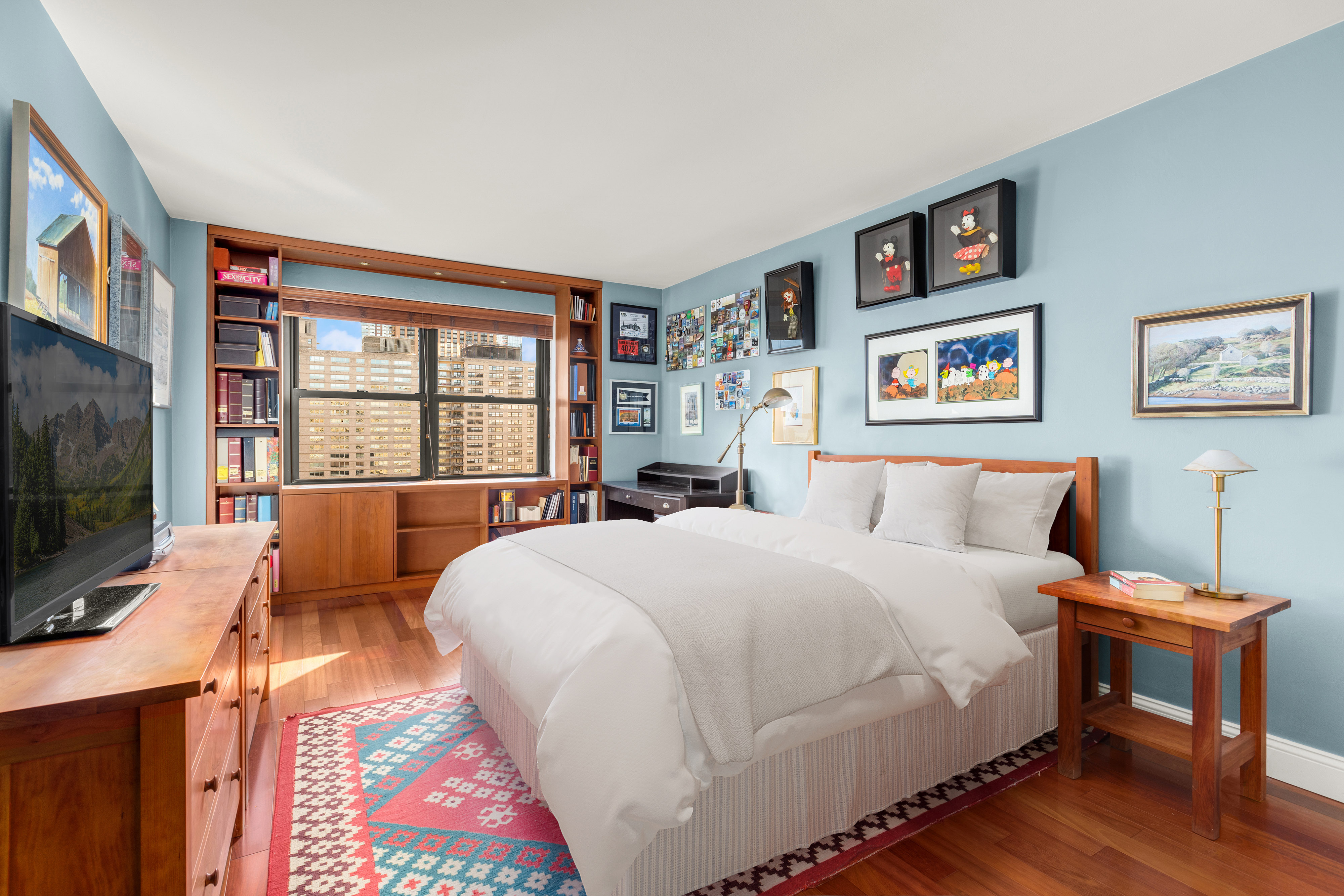 185 West End Avenue, Unit 24H Manhattan, NY 10023 - Photo 4 of 10 a bedroom with a bed a dresser and a flat screen tv