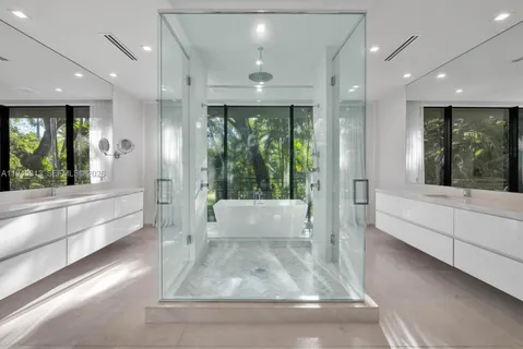 a large white bathroom with a large tub and shower