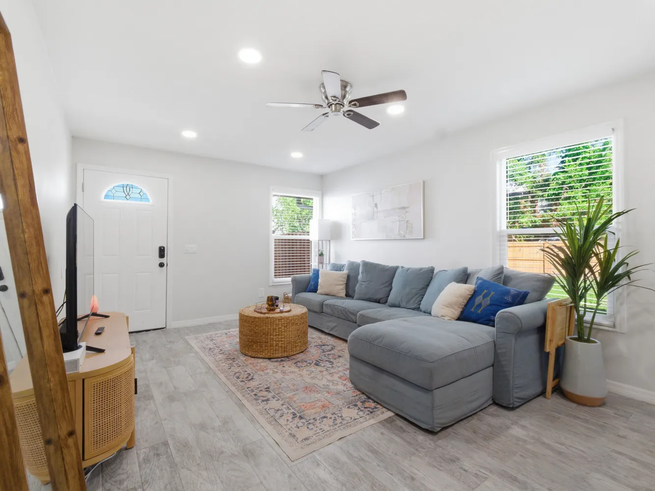 a living room with furniture a chandelier and a flat screen tv