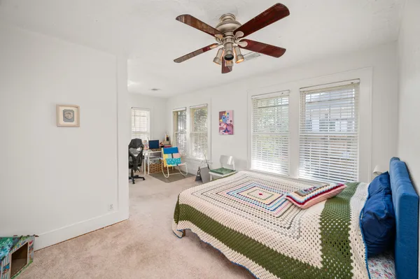 a bedroom with a bed a chandelier and a window