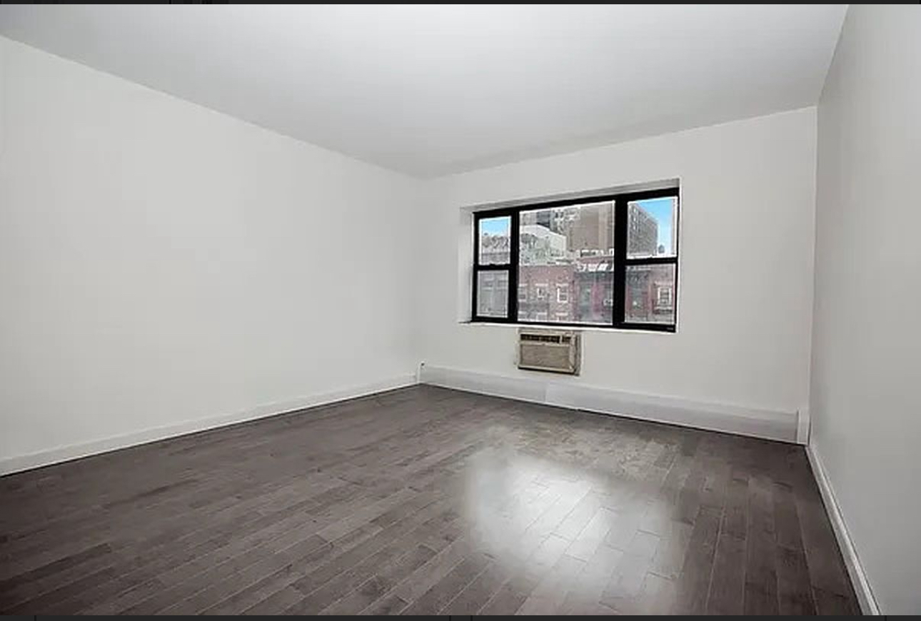400 East 14th Street, Unit 4C Manhattan, NY 10009 - Photo 3 of 7 an empty room with wooden floor and windows