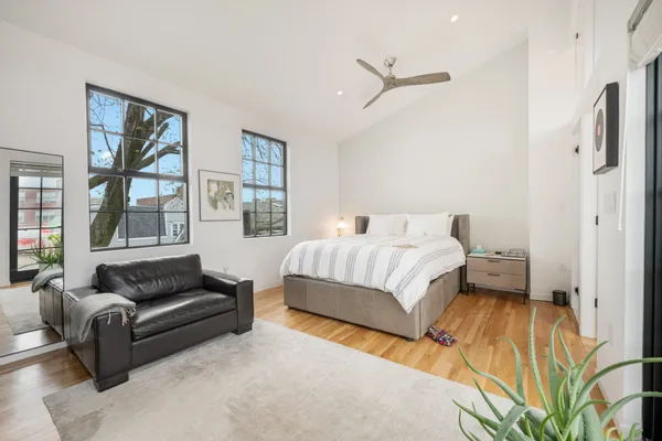 a spacious bedroom with a bed couch and a window