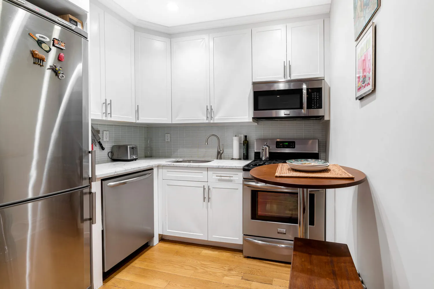 a kitchen with stainless steel appliances granite countertop a refrigerator a stove and a sink