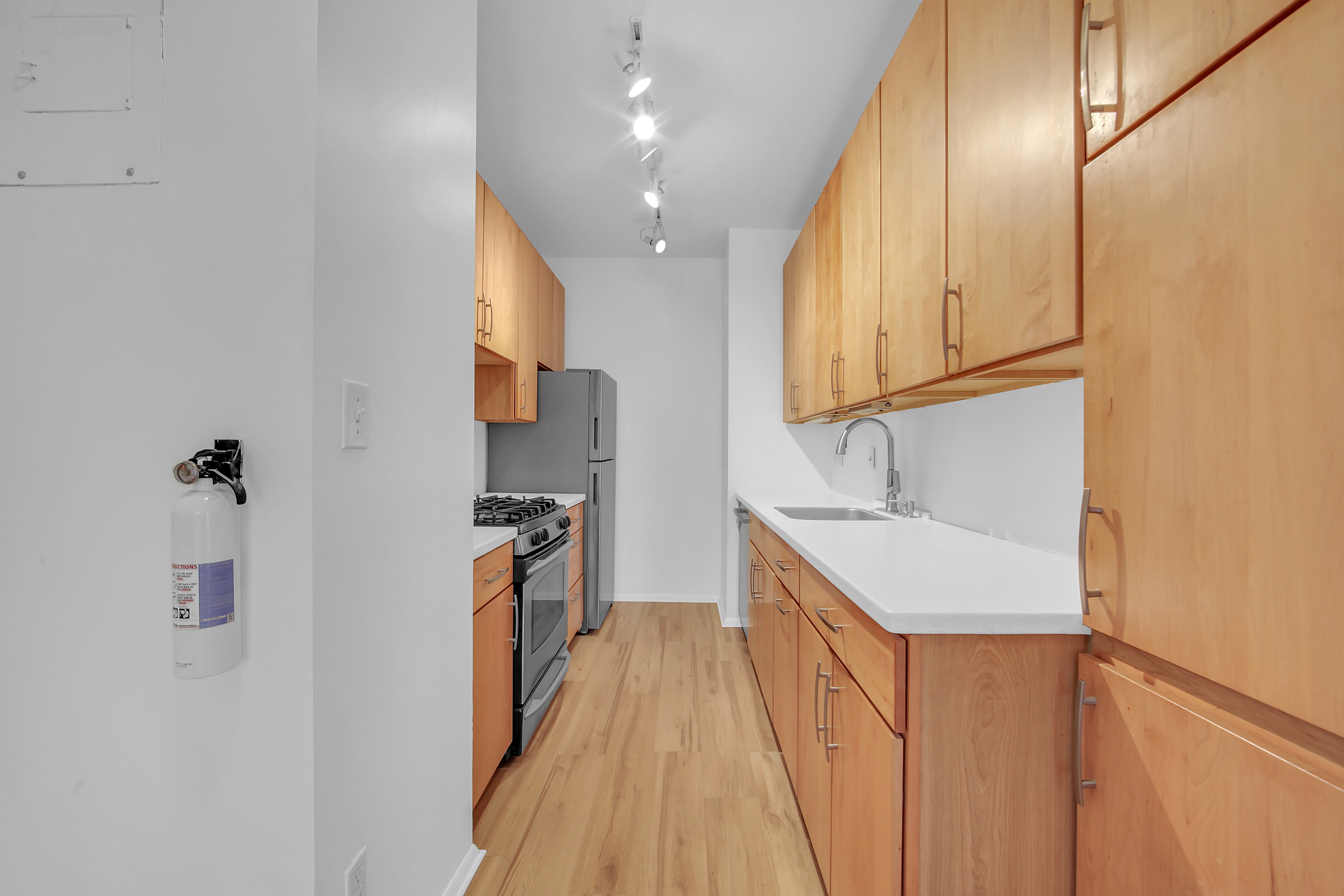75 Livingston Street, Unit 9B Brooklyn, NY 11201 - Photo 6 of 13 a kitchen with stainless steel appliances granite countertop a sink a stove and a refrigerator