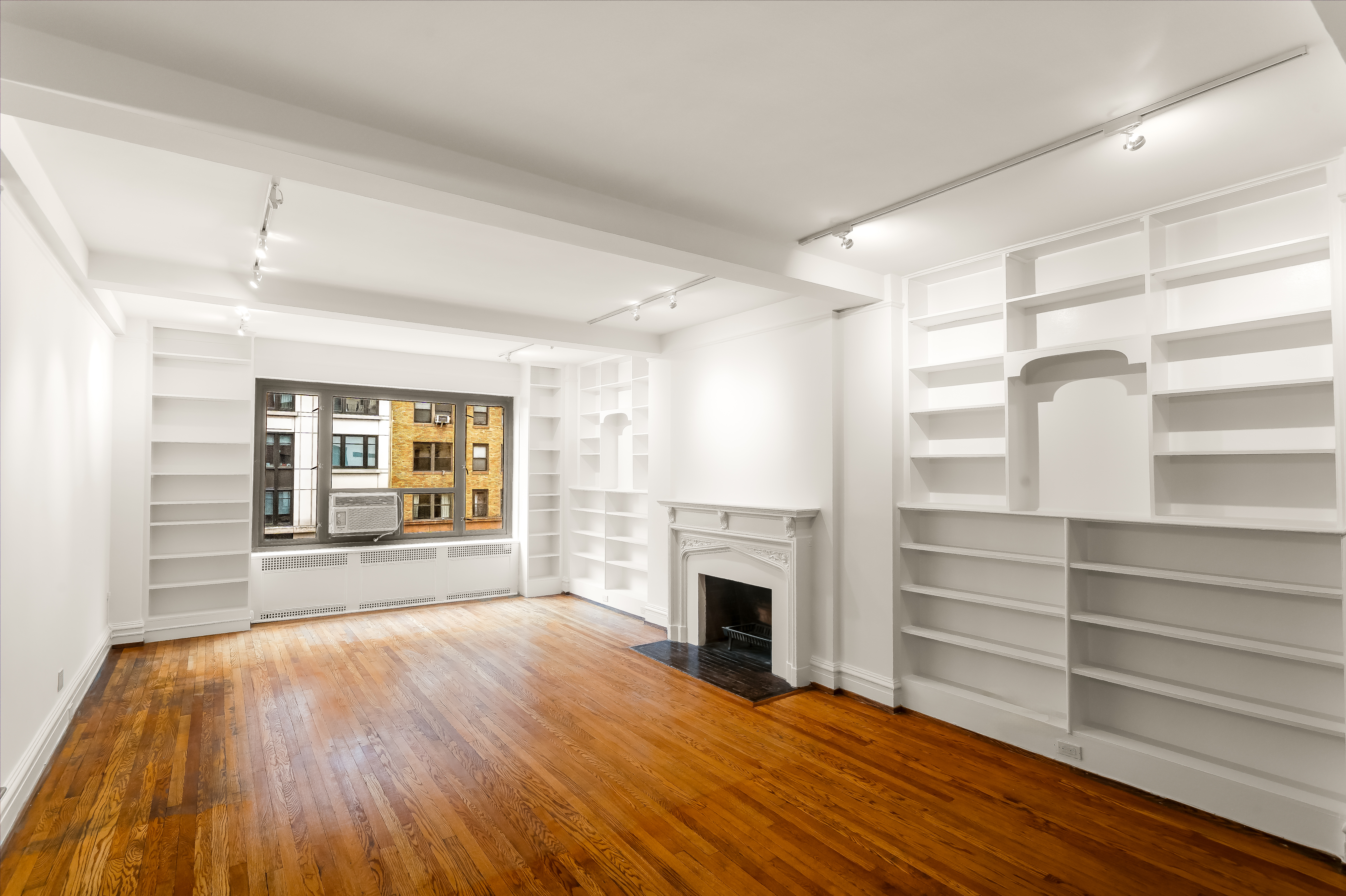 180 East 79th Street, Unit 5A Manhattan, NY 10075 - Photo 2 of 19 a view of empty room with wooden floor and fireplace