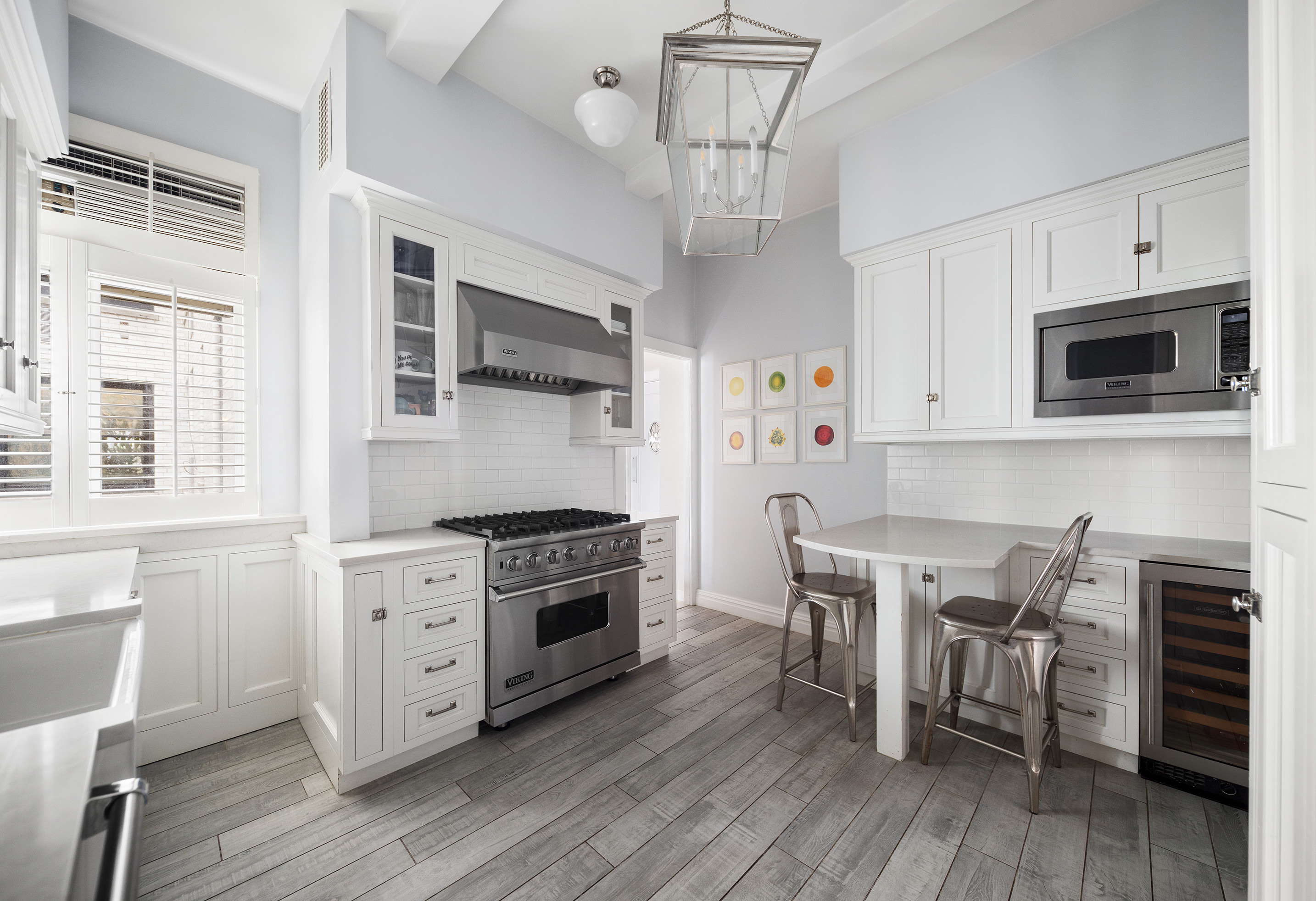 570 Park Avenue, Unit 10D Manhattan, NY 10065 - Photo 8 of 17 a kitchen with stainless steel appliances a white stove top oven cabinets and a wooden floor