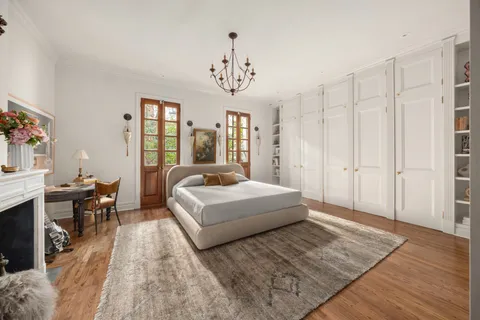 a spacious bedroom with a bed a table and a dresser