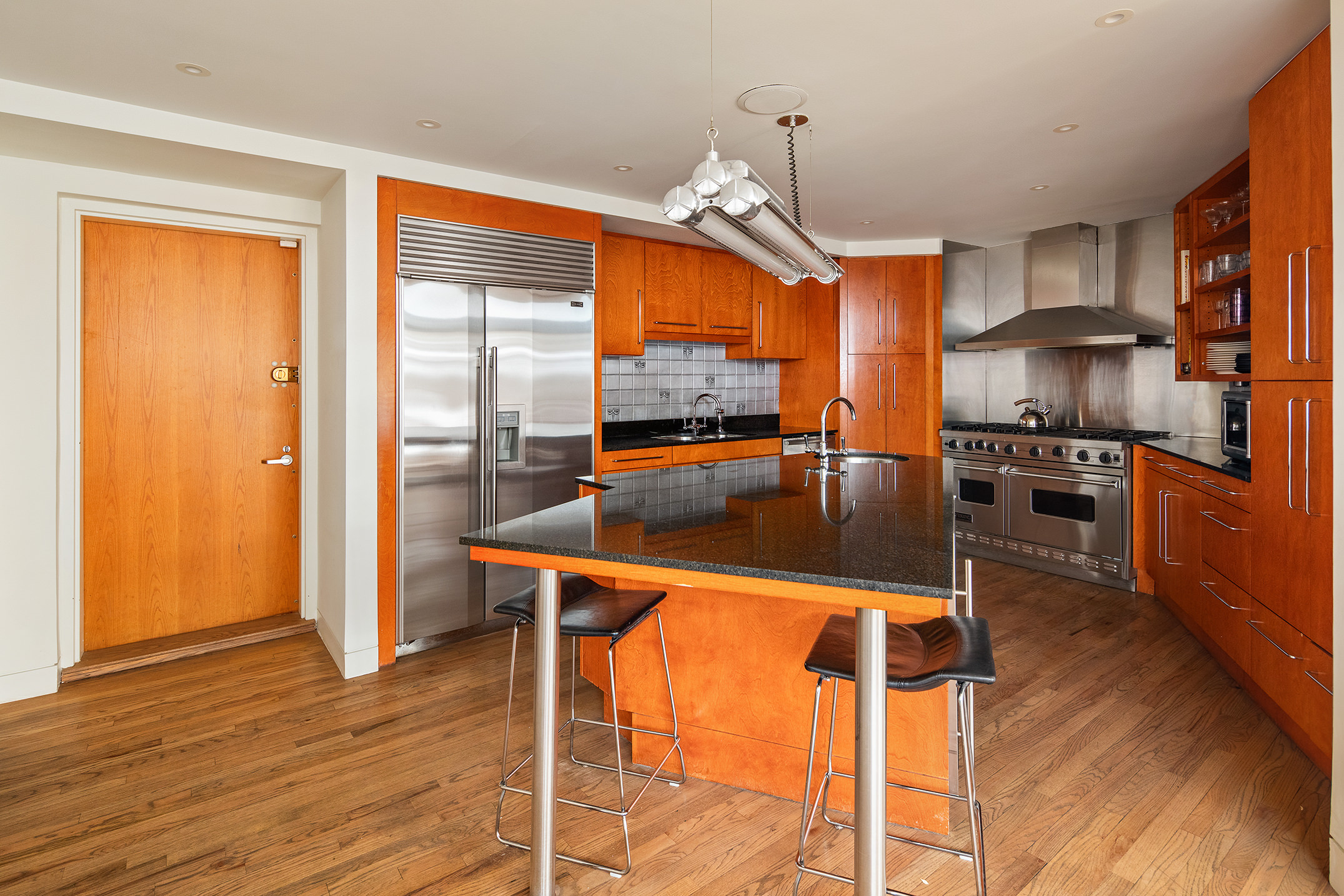 152 Franklin Street, Unit PH Manhattan, NY 10013 - Photo 14 of 17 a kitchen with stainless steel appliances granite countertop a stove top oven a refrigerator and a view of living room