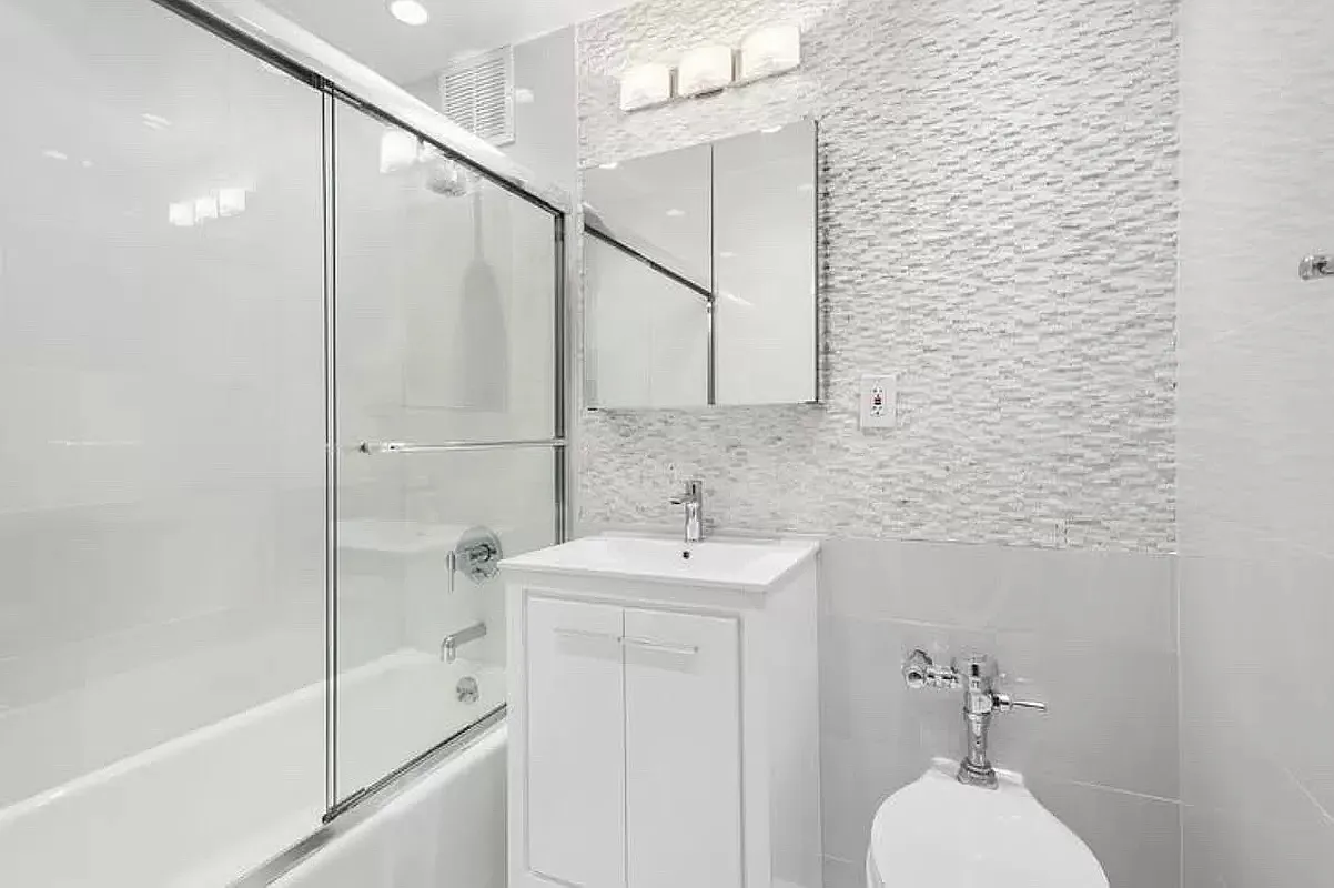 300 East 90th Street, Unit 6D Manhattan, NY 10128 - Photo 5 of 7 a bathroom with a sink a mirror and a shower