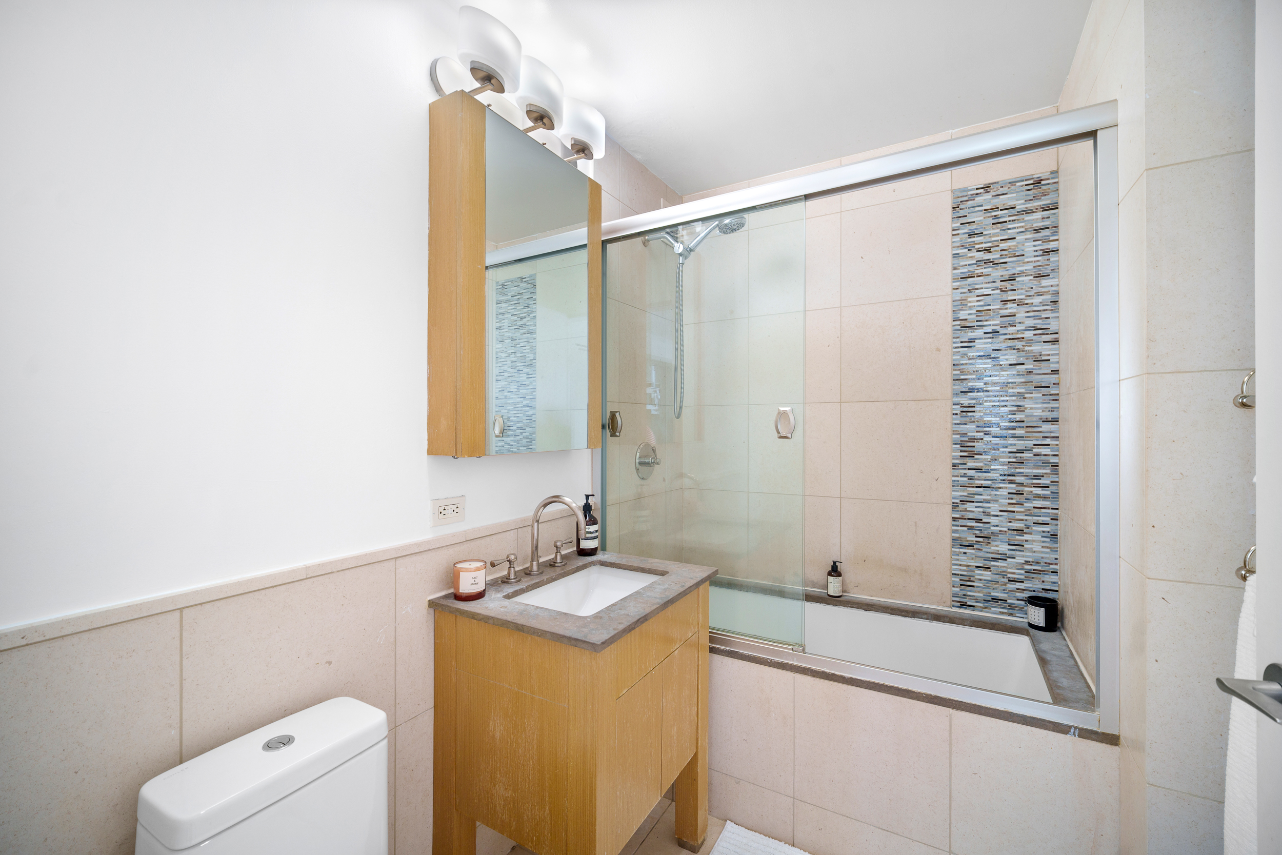 350 West 42nd Street, Unit 27K Manhattan, NY 10036 - Photo 9 of 18 a bathroom with a sink a toilet and shower