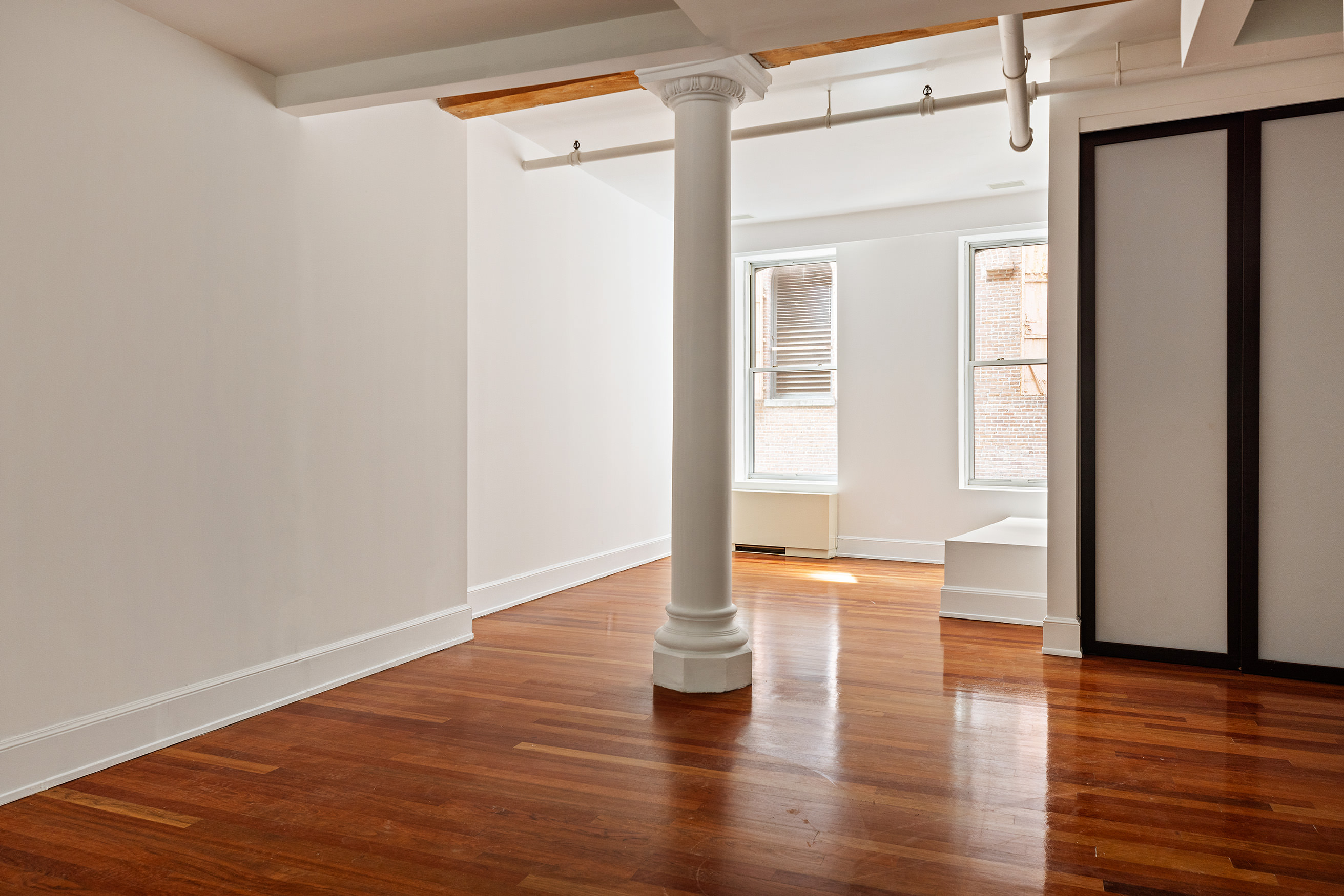 285 Lafayette Street, Unit 2B Manhattan, NY 10012 - Photo 7 of 19 a view of empty room with wooden floor and fan