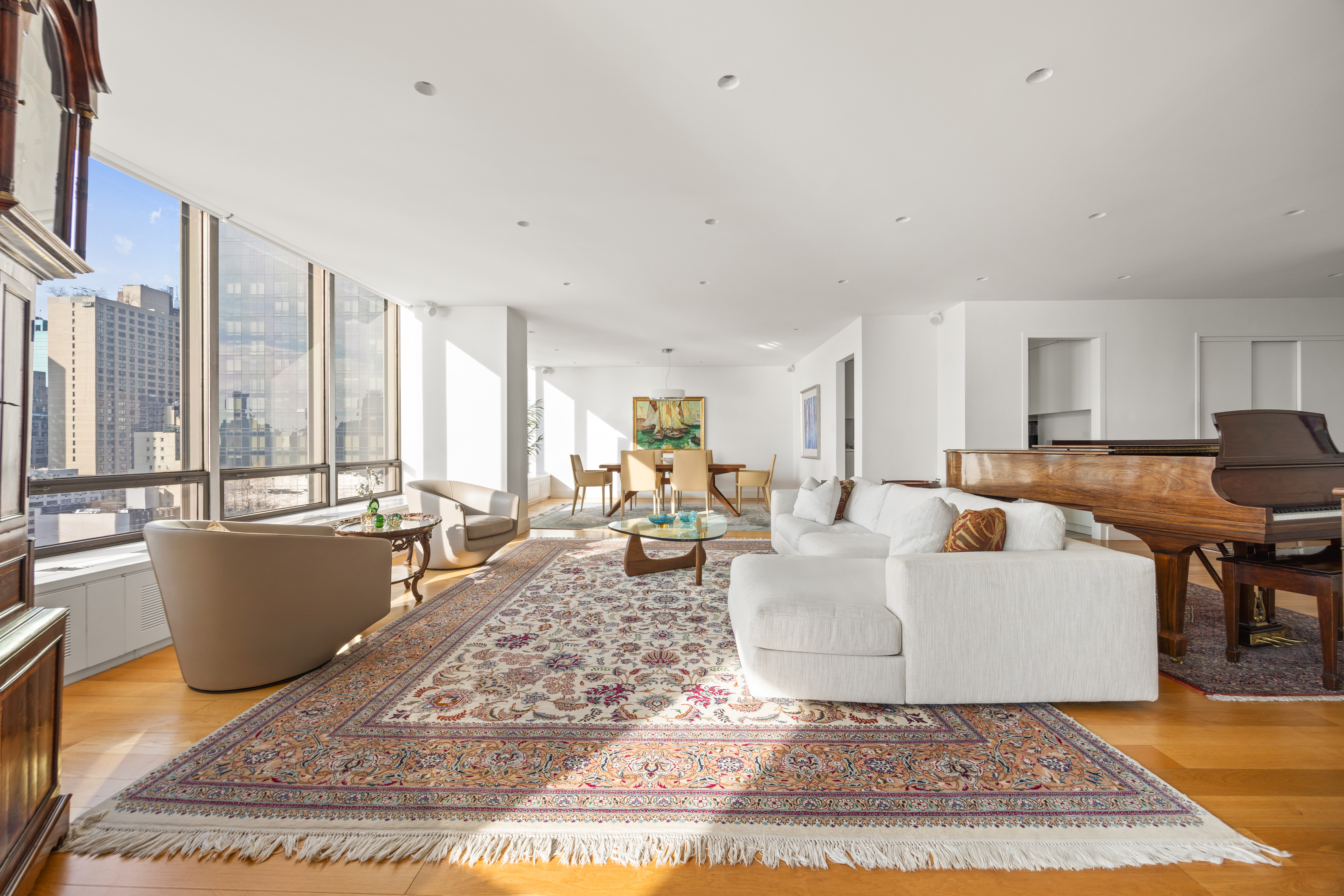 860 United Nations Plaza, Unit 16G Manhattan, NY 10017 - Photo 3 of 12 a living room with furniture a rug and a dining table