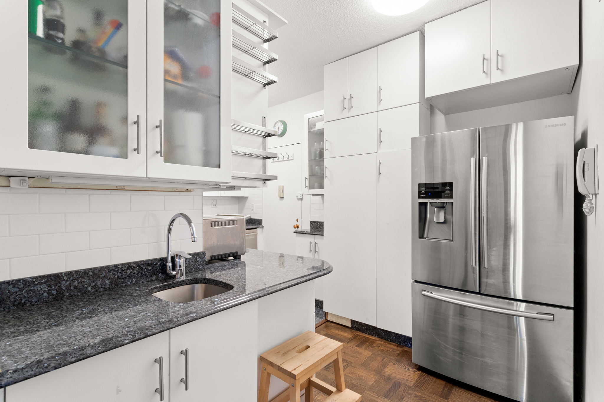 60 East 8th Street, Unit 24J Manhattan, NY 10003 - Photo 7 of 16 a kitchen with stainless steel appliances a refrigerator sink and cabinets