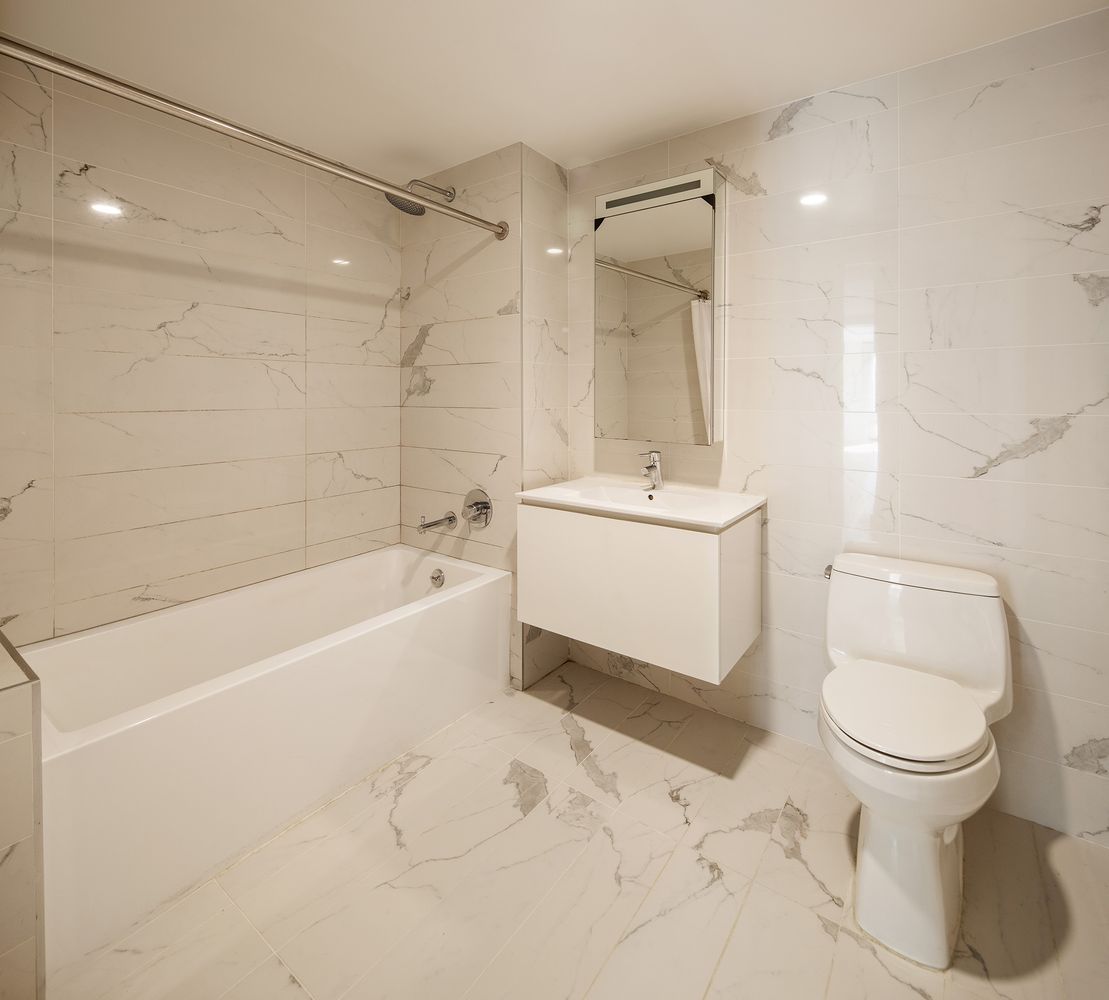 1790 3rd Avenue, Unit 505 Manhattan, NY 10029 - Photo 5 of 7 a bathroom with a sink toilet and shower