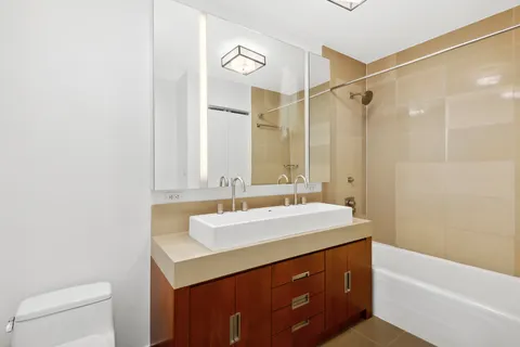a bathroom with a sink a toilet and a mirror