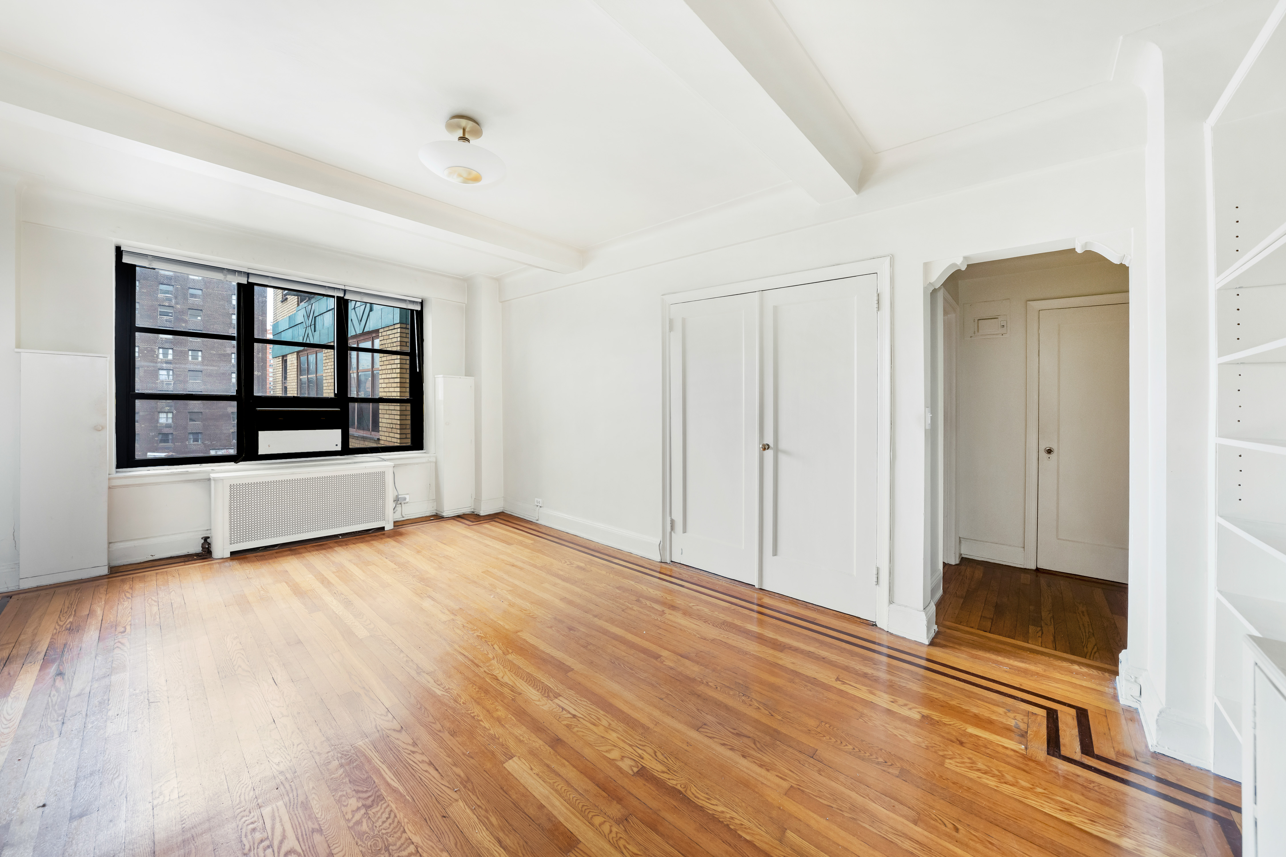 235 East 22nd Street, Unit 9M Manhattan, NY 10010 - Photo 4 of 15 wooden floor in an empty room with a window