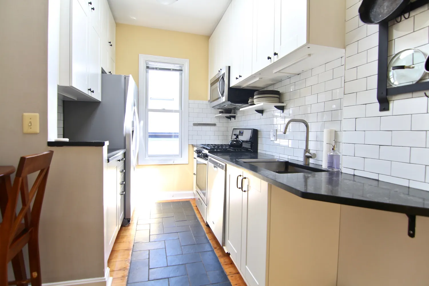 a kitchen with stainless steel appliances a sink a refrigerator and a stove