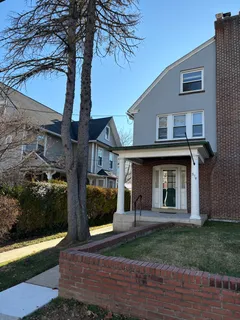 a view of a house with brick walls and a yard with plants