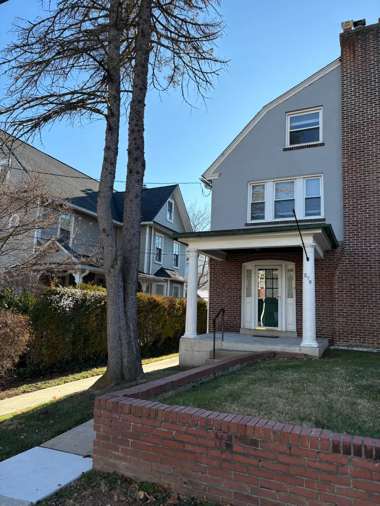 a view of a house with brick walls and a yard with plants