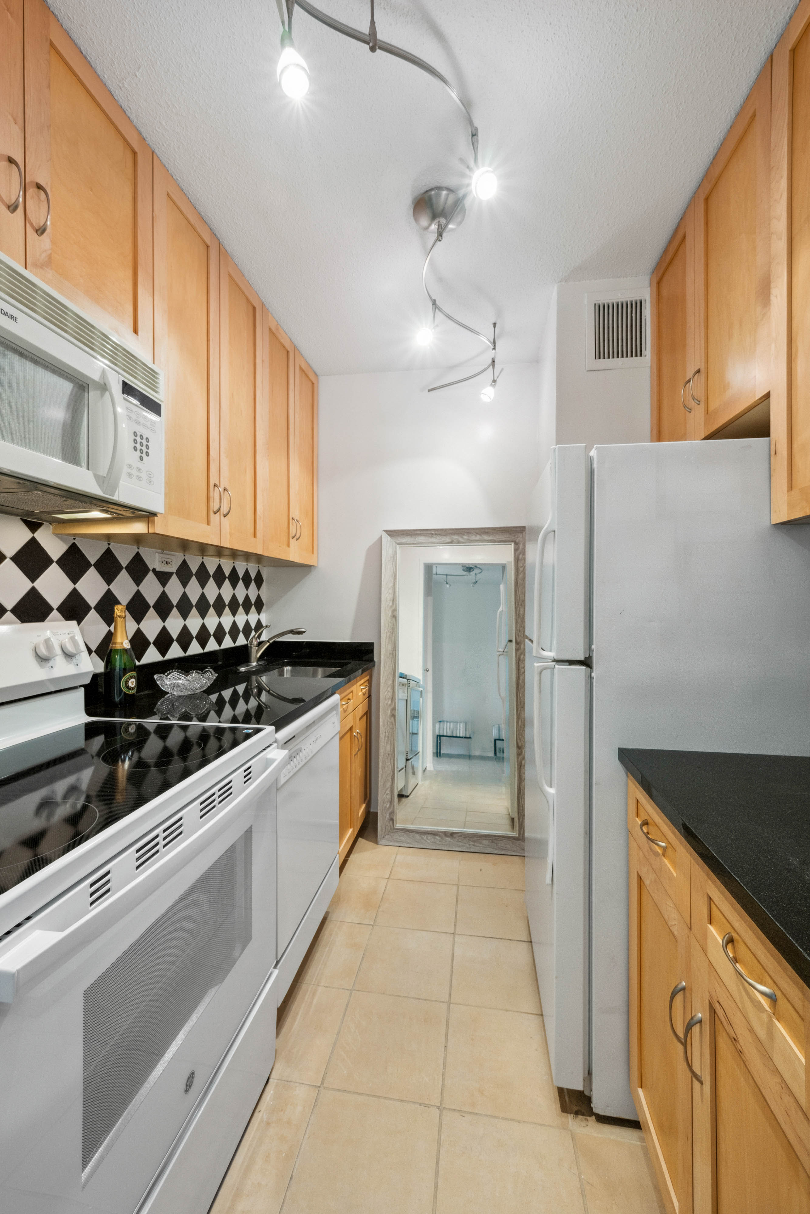 300 East 54th Street, Unit 15C Manhattan, NY 10022 - Photo 6 of 10 a kitchen with stainless steel appliances a refrigerator and a stove