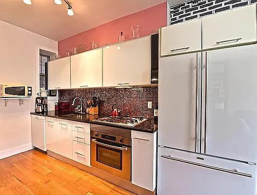 138 Edgecombe Avenue, Unit 3A Manhattan, NY 10030 - Photo 2 of 10 a kitchen with stainless steel appliances granite countertop a sink and a refrigerator