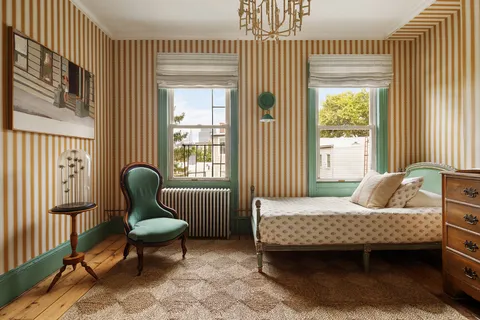 a bedroom with a bed chair and a window