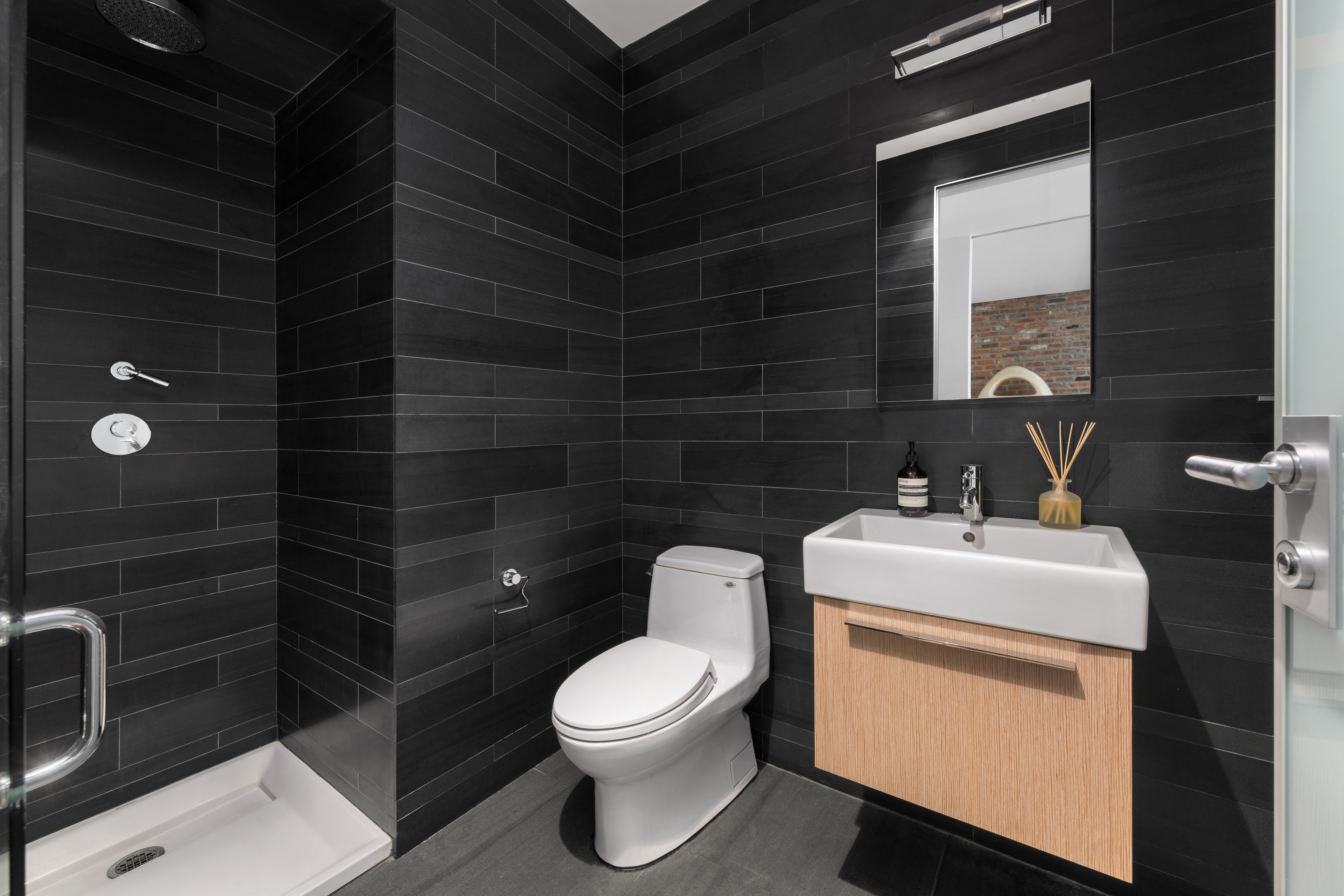 74 Warren Street, Unit 5W Manhattan, NY 10007 - Photo 12 of 15 a bathroom with a toilet sink a shower and mirror