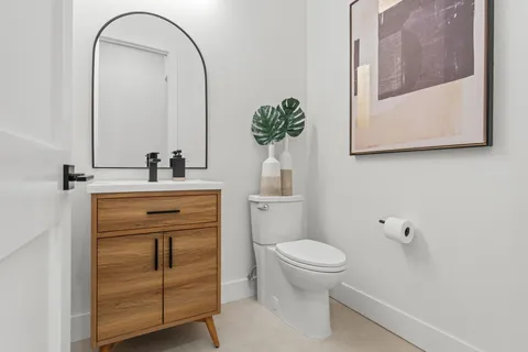 a bathroom with a sink a toilet and mirror