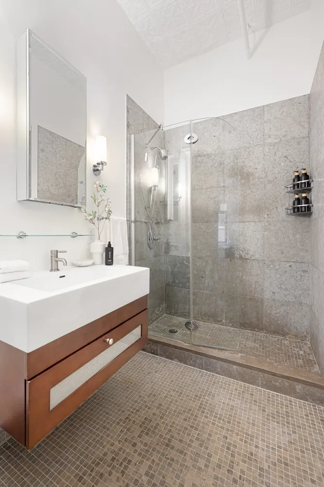 a bathroom with a sink a toilet and shower