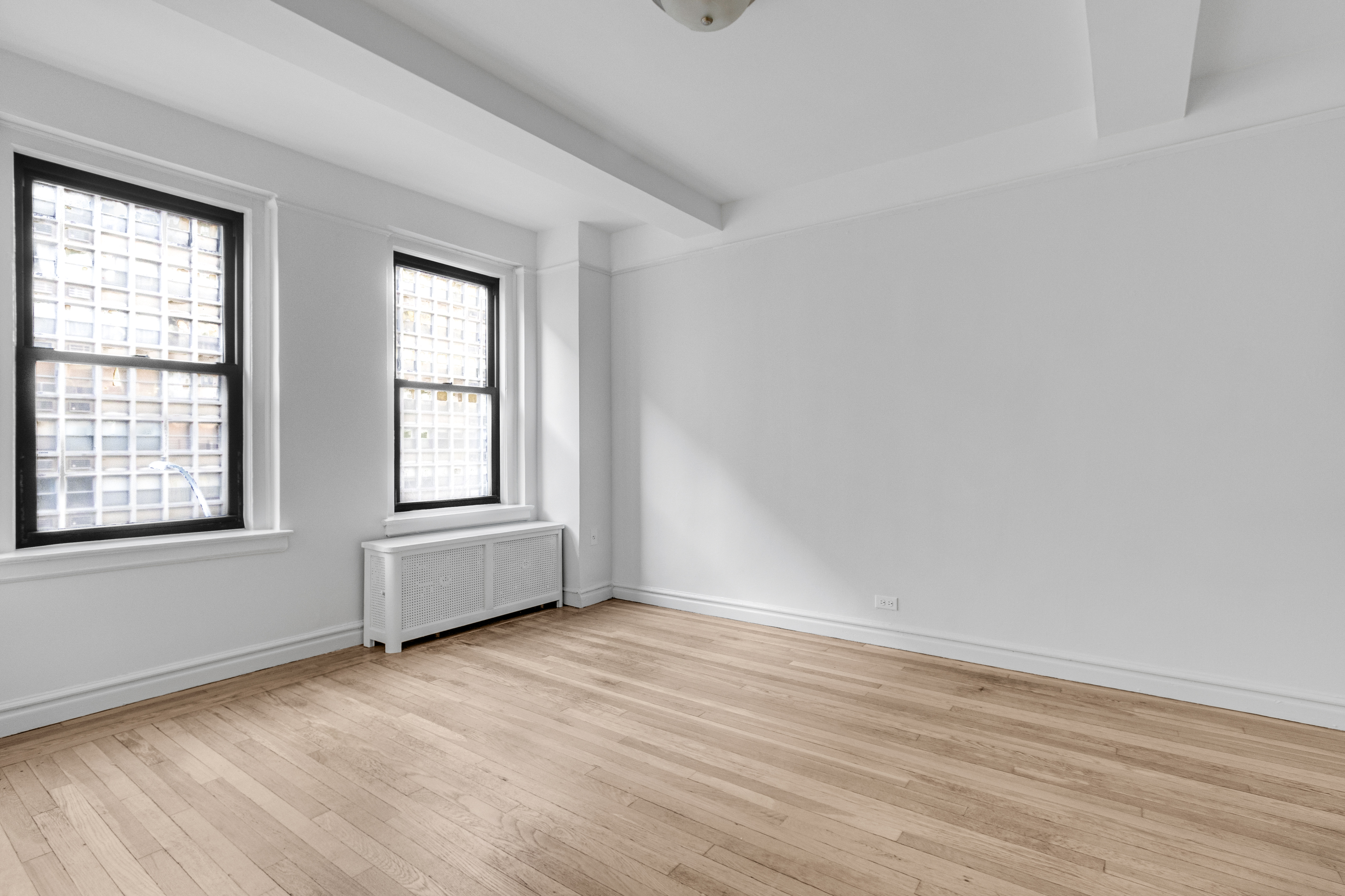 127 West 96th Street, Unit 4D Manhattan, NY 10025 - Photo 10 of 14 an empty room with wooden floor and windows