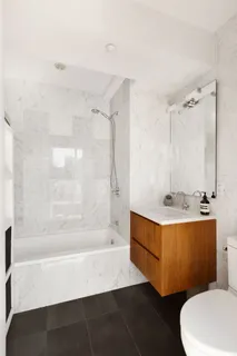 a bathroom with a sink a toilet a mirror and bathtub