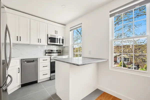 a kitchen with stainless steel appliances granite countertop a stove a sink and a microwave