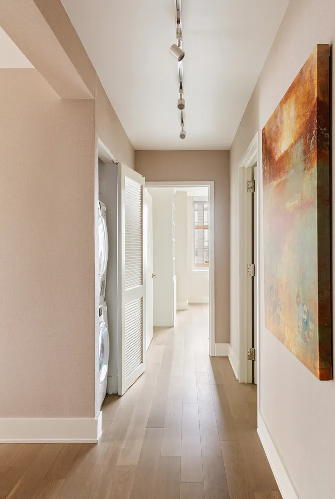 a view of a hallway with wooden floor and chandelier