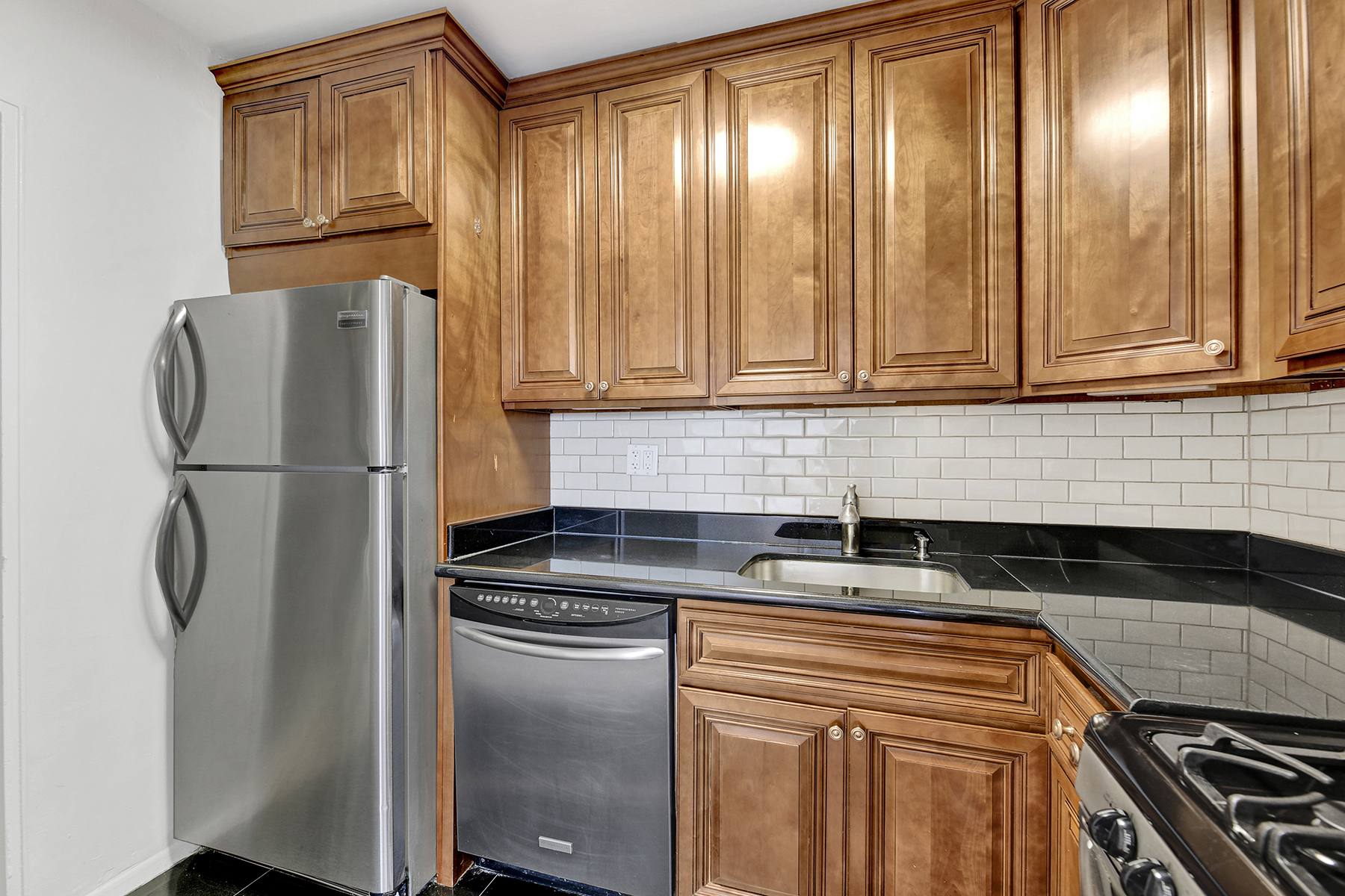 125 Beach 124th Street, Unit 5K Queens, NY 11694 - Photo 16 of 21 a kitchen with granite countertop cabinets and refrigerator