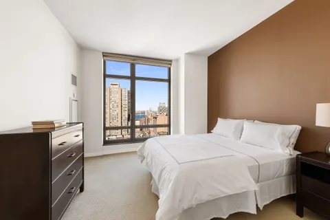 a bedroom with a bed and a large window