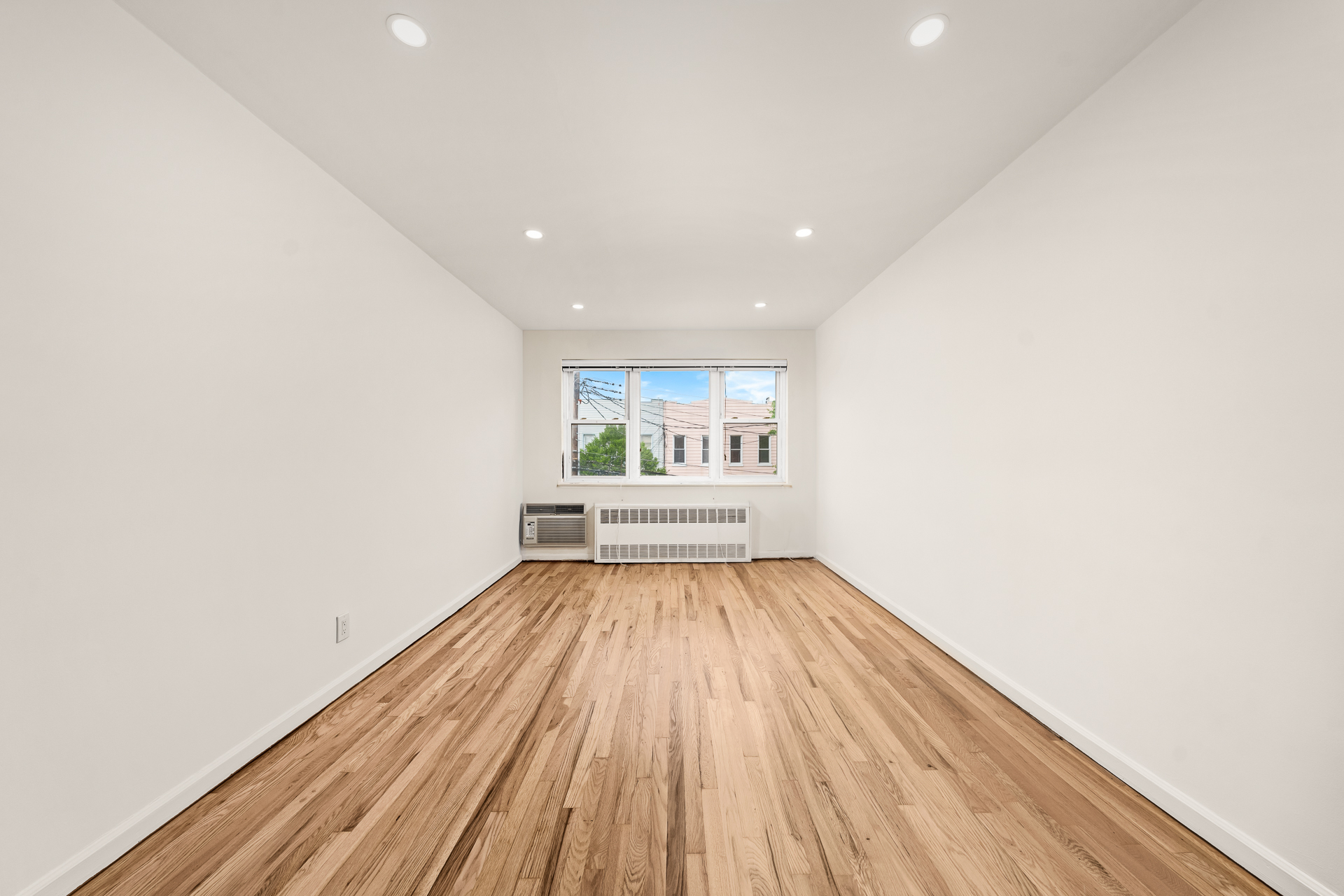 412 Fairview Avenue, Unit 1 Queens, NY 11385 - Photo 5 of 9 a view of an empty room with wooden floor and a window