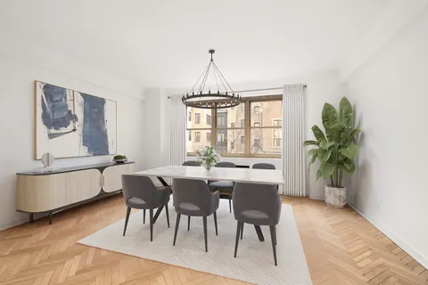 a dining room with furniture potted plants and wooden floor
