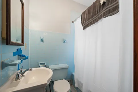 a bathroom with a sink a toilet and mirror