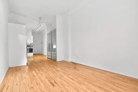 a view of an empty room with wooden floor