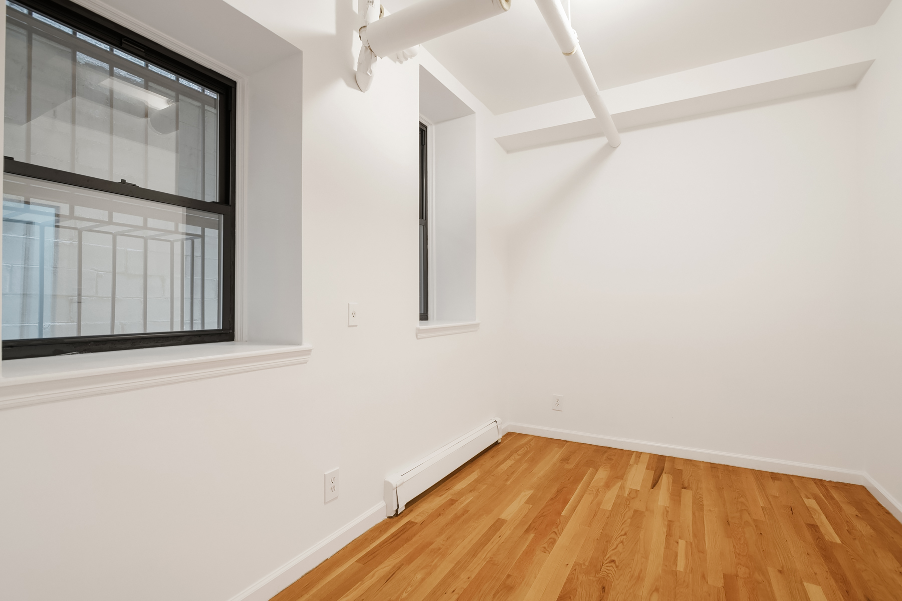 205 West 10th Street, Unit GARDEN Manhattan, NY 10014 - Photo 5 of 8 a view of a room with wooden floor and cabinet