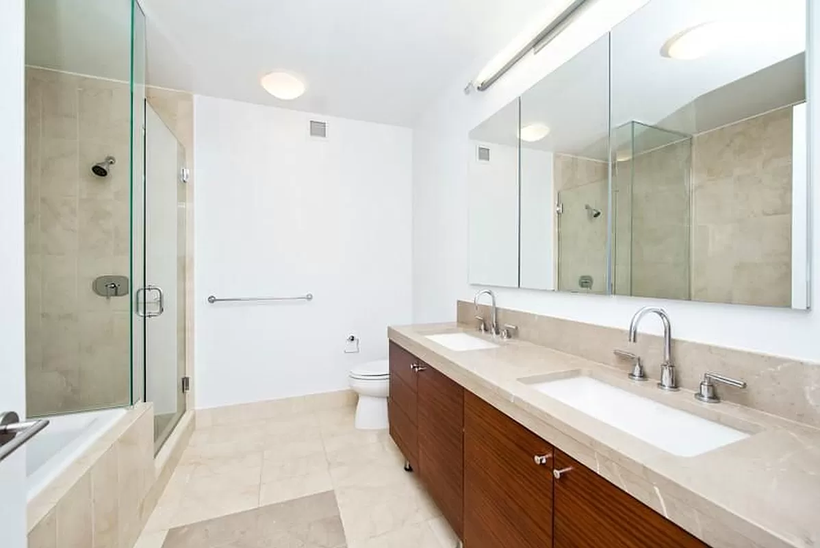 30 West Street, Unit 6B Manhattan, NY 10004 - Photo 9 of 13 a bathroom with a double vanity sink mirror double and shower