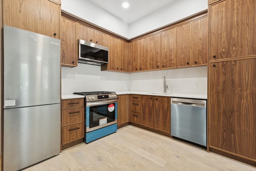 144 Somers Street, Unit 2 Brooklyn, NY 11233 - Photo 2 of 10 a kitchen with stainless steel appliances a refrigerator a stove a microwave and cabinets