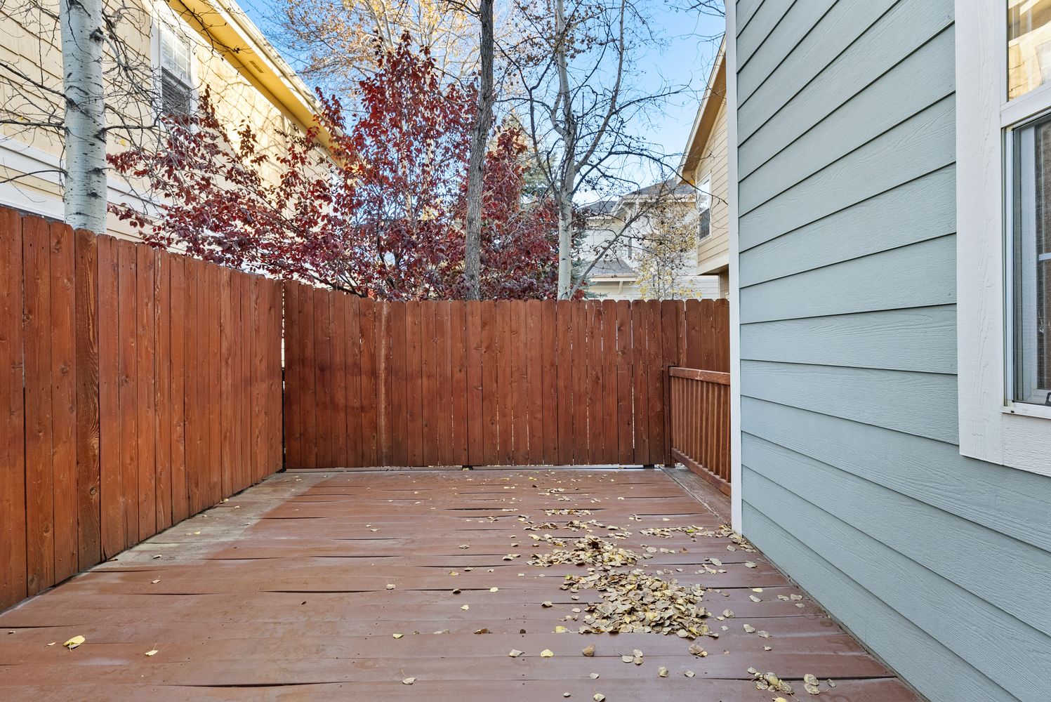a view of backyard with wooden fence