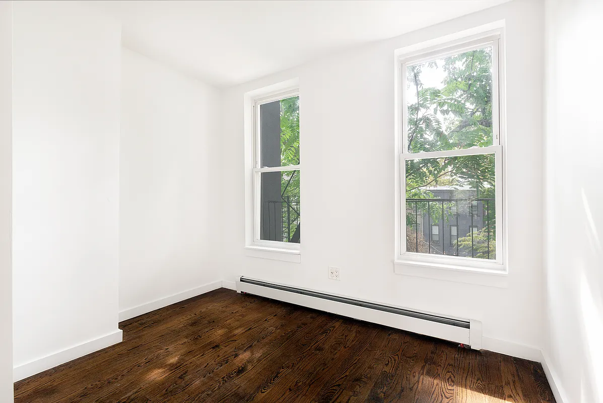 834 Halsey Street, Unit 2 Brooklyn, NY 11233 - Photo 4 of 10 an empty room with wooden floor and windows