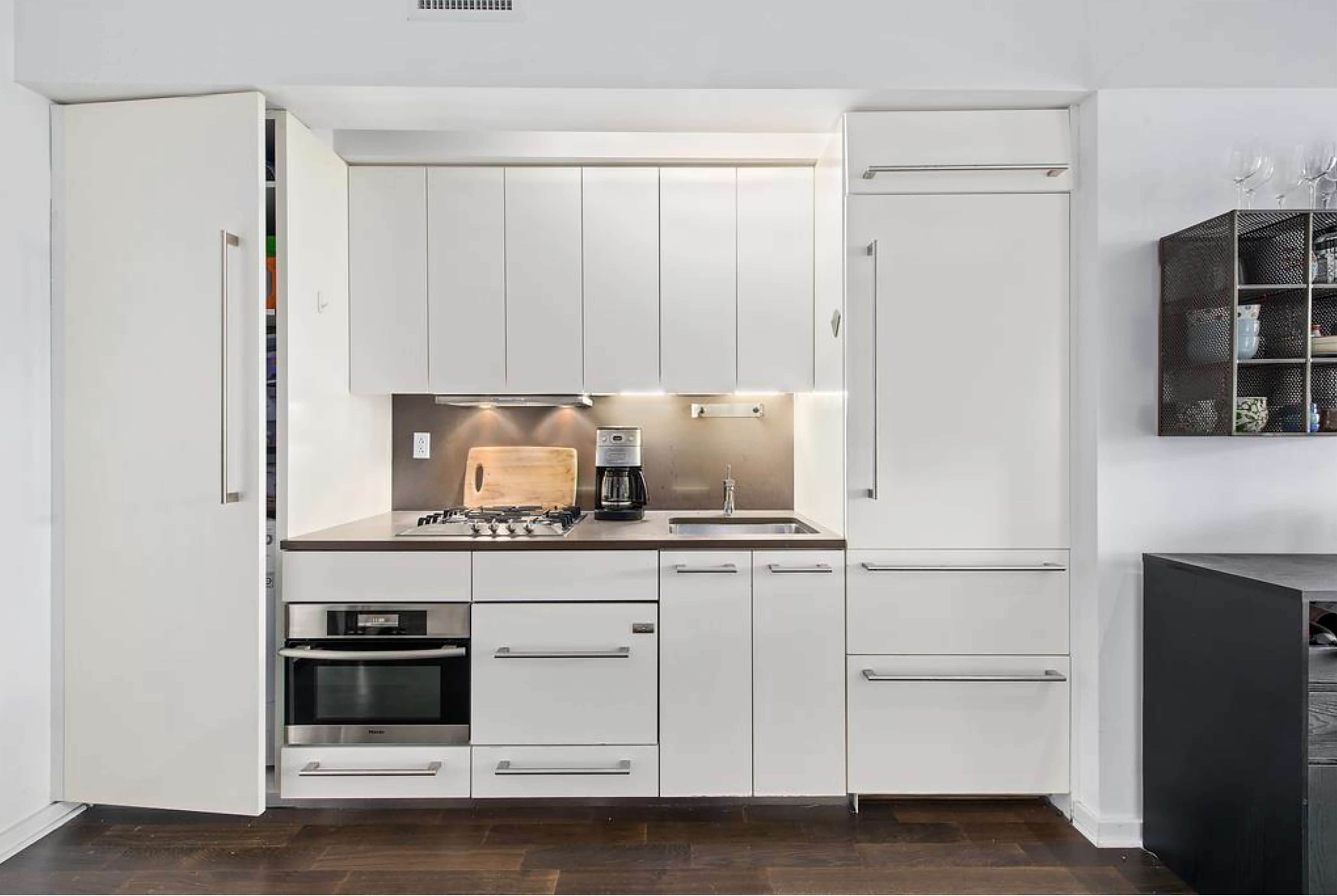 340 East 23rd Street, Unit 9J Manhattan, NY 10010 - Photo 3 of 5 a kitchen with stainless steel appliances a stove and white cabinets