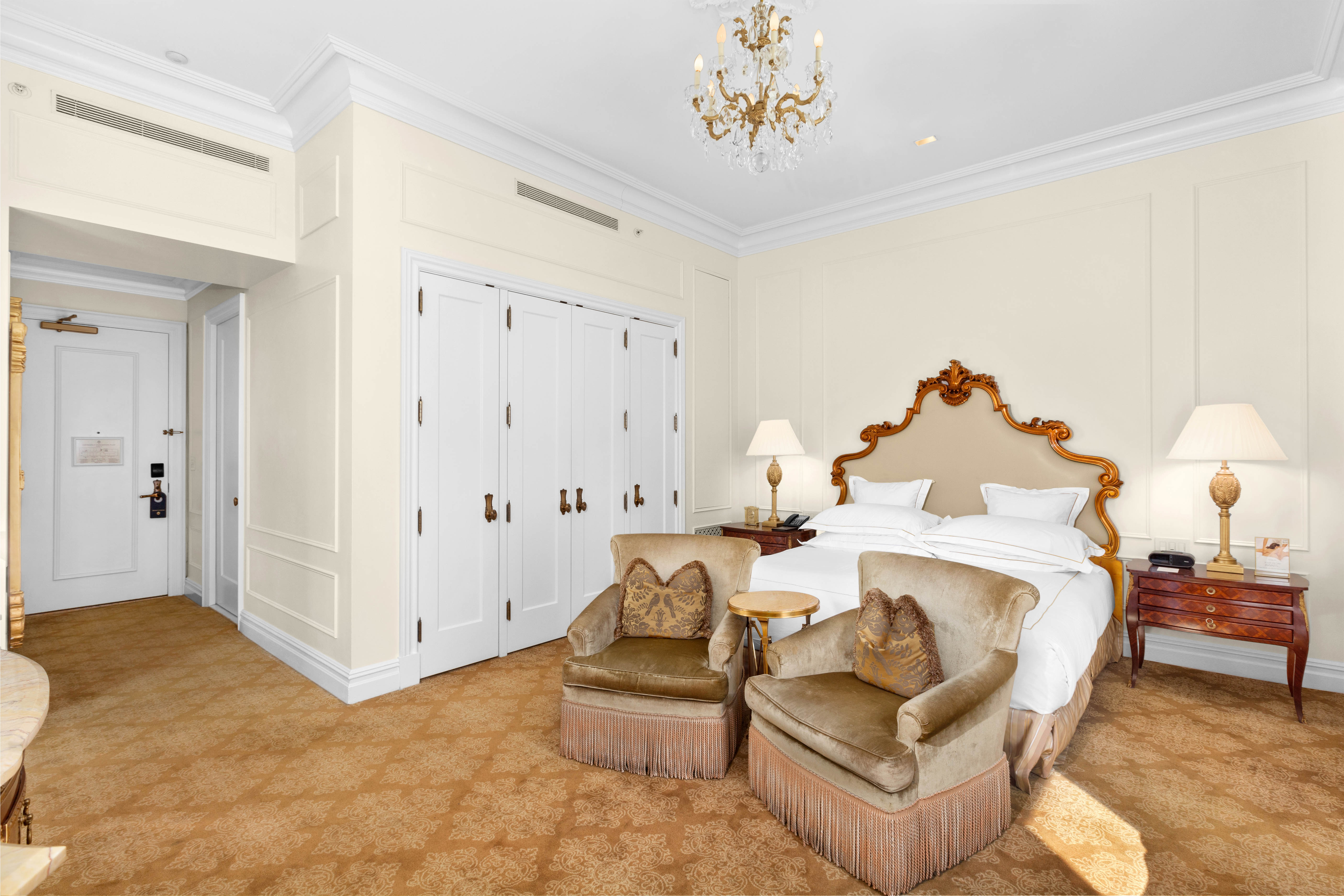 1 Central Park South, Unit 1241 Manhattan, NY 10019 - Photo 2 of 14 a spacious bedroom with a bed and a chandelier