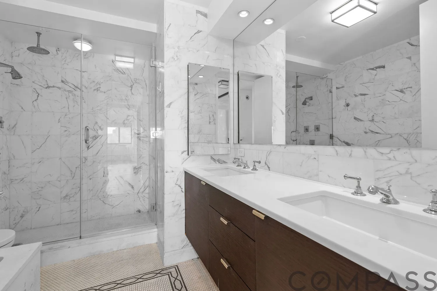 a bathroom with a double vanity sink mirror and shower