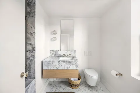 a bathroom with a sink toilet and mirror