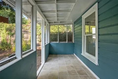 a view of empty room with wooden floor and windows