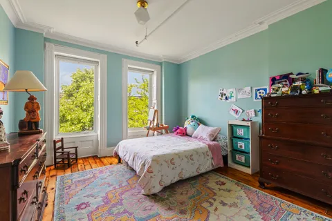 a bedroom with a bed and a flat tv screen on dresser